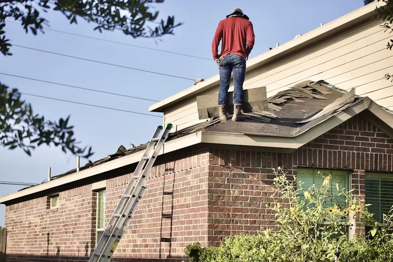 Professional roofer working on a residential roof in White Lake Hills